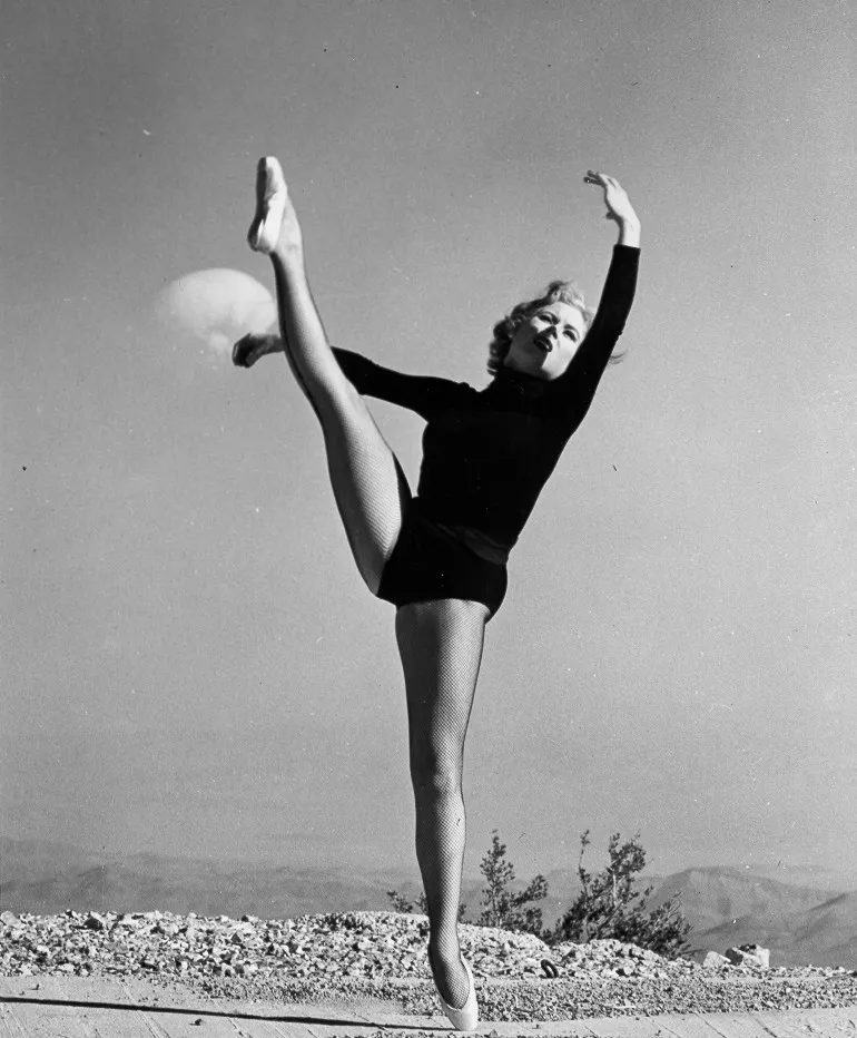 Photograph of a dancer posing in front of a 1953 nuclear test
